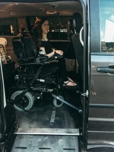 Tori sitting in her wheelchair in the wheelchair accessible van they rented.