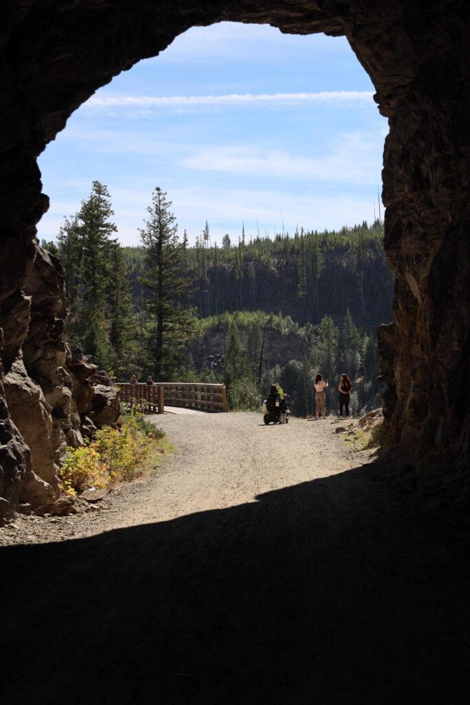 Tori and two other people standing at the edge of the canyon and taking photos.