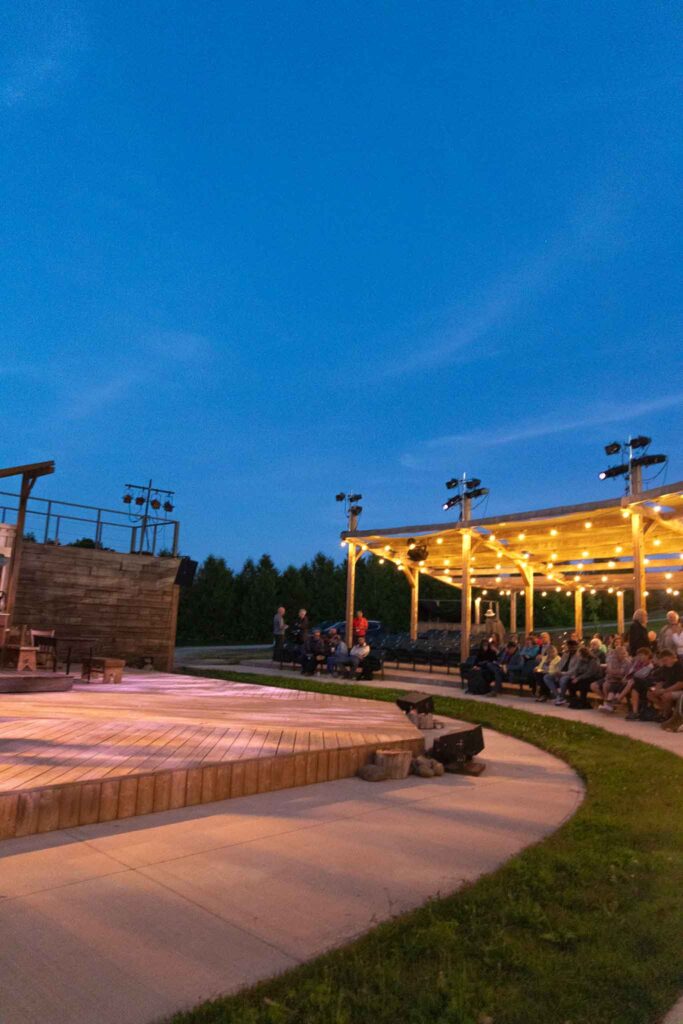 An evening view of the open-air theater in Central Huron, Ontario, decorated with glowing fairy lights. A wheelchair accessible travel blogger visited this venue to highlight inclusive arts experiences.