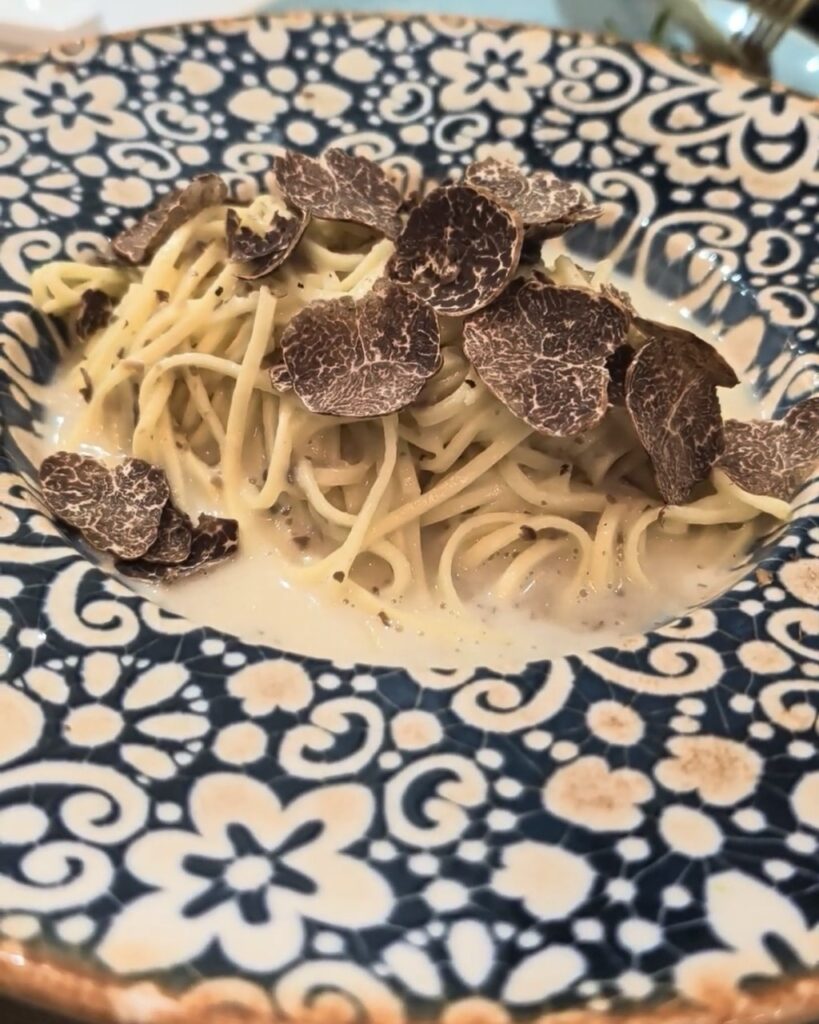 Tagliolini al tartufo — handmade pasta tossed in Parmesan and topped with generous black truffle shavings, served at Unico Ristorante Italiano, a wheelchair accessible Italian restaurant in Malaga, Spain