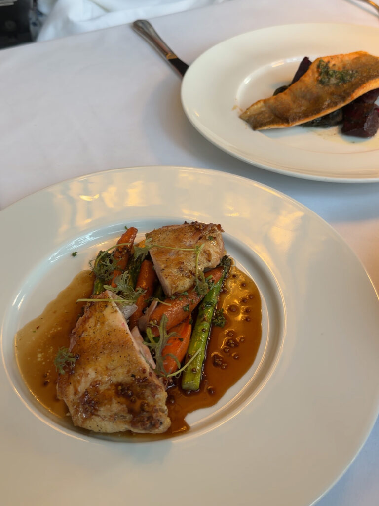 Two fine dining plates — pan-seared fish with beets and roasted cornish hen with carrots and asparagus — at The Bruce Hotel restaurant in Stratford, Ontario