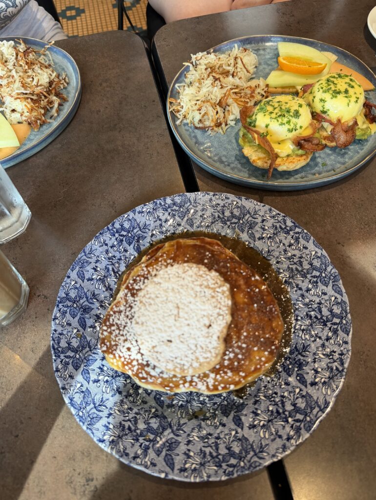 A breakfast spread of eggs Benedict, hash browns, fresh fruit, and powdered-sugar pancakes at Romeo's restaurant in Stratford, Ontario