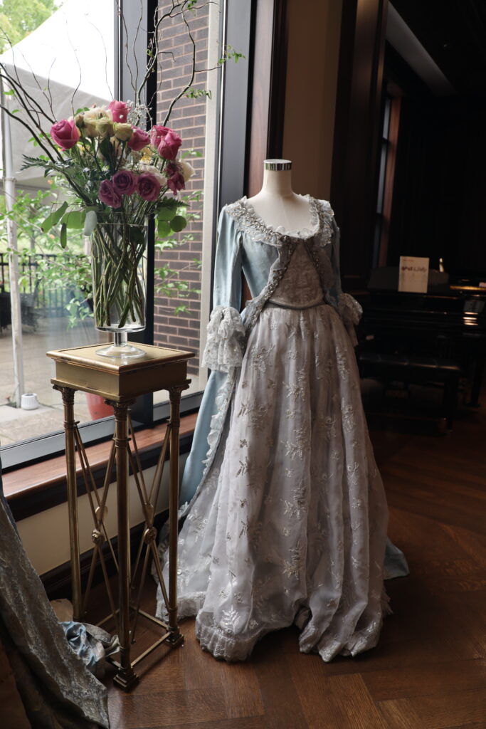 A pale blue beaded Stratford Festival costume gown displayed on a mannequin near a window at The Bruce Hotel in Stratford, Ontario