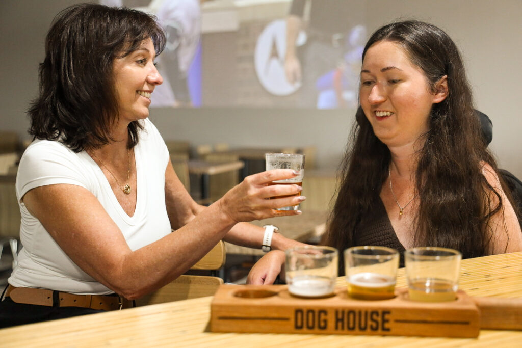 Woman in a power wheelchair enjoying a craft beer flight at Dog House in Petawawa
