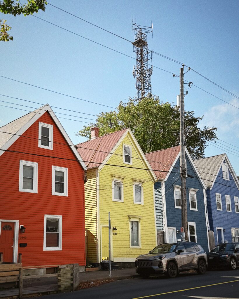 Row of brightly painted red, yellow and blue wooden houses on a street in Halifax, Nova Scotia, Canada