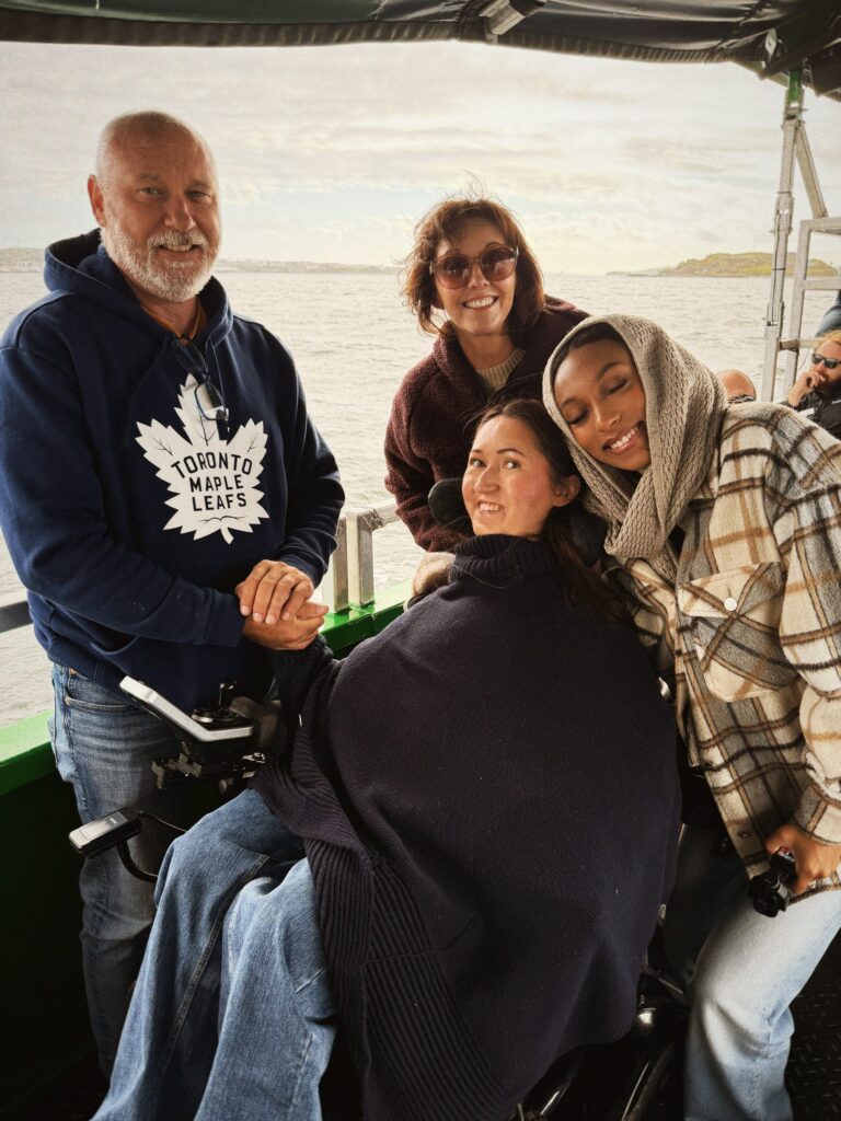 Tori Hunter, a wheelchair user and disabled travel blogger, taking a group selfie with her parents and friend on the Harbour Hopper tour as it cruises across Halifax Harbour in Nova Scotia, Canada